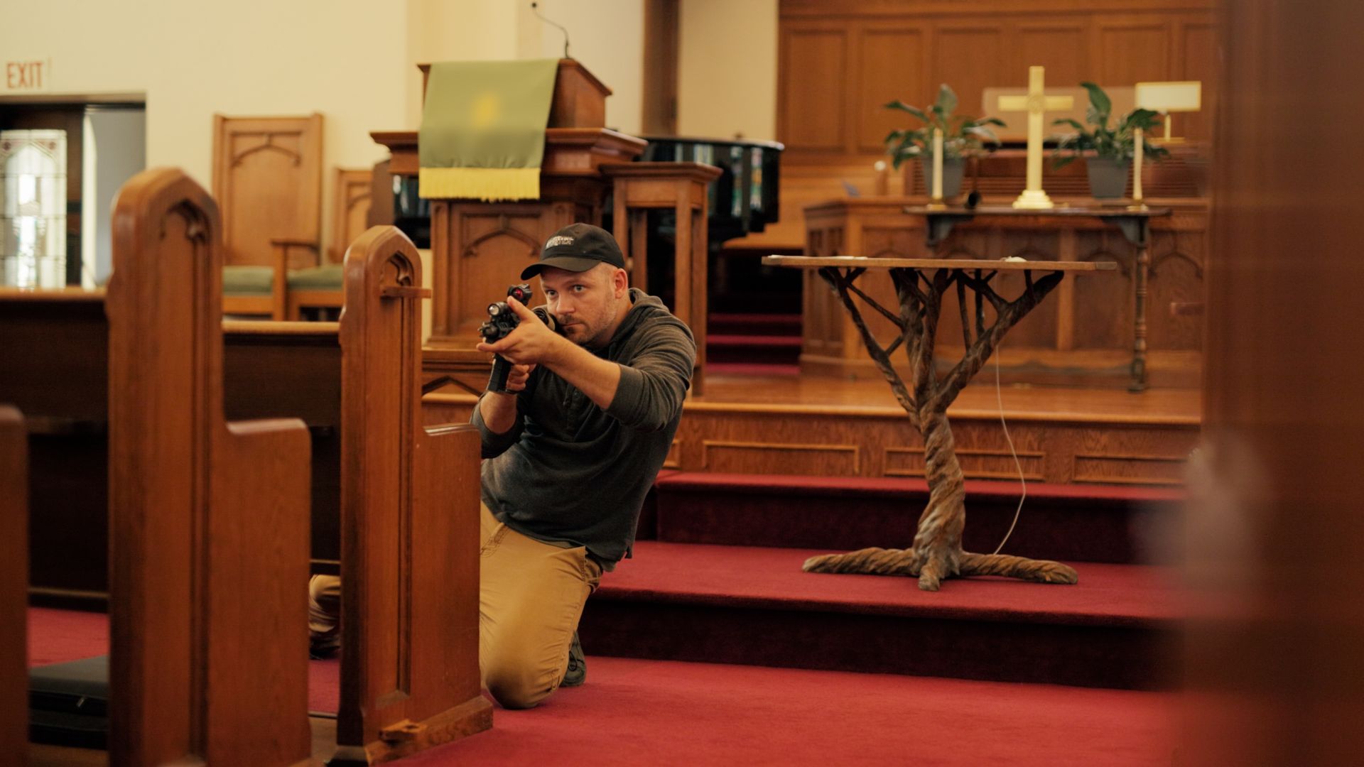 Hiding behind a pew, and looking down the scope of the rifle