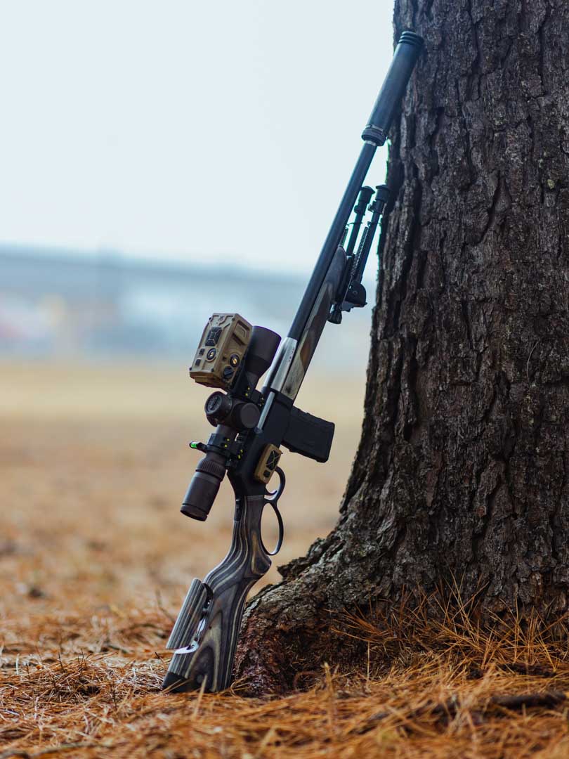 Henry SPD Tactical Lever action gun resting against a tree