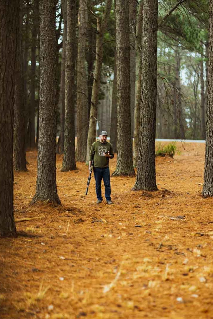 Jared walking through the woods with his lever action rifle